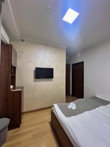 a bedroom with a bed and a tv on the wall at Mashtots Hotel in Yerevan