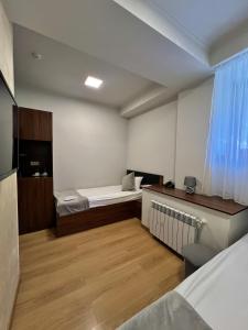 a small room with two beds and a desk at Mashtots Hotel in Yerevan