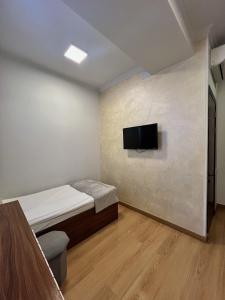 a bedroom with a bed and a tv on a wall at Mashtots Hotel in Yerevan