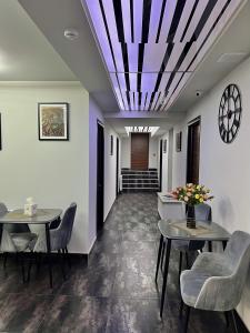 a hallway with two tables and chairs and a clock at Mashtots Hotel in Yerevan