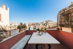 a balcony with a table and potted plants on it at Scala Lovely Terrace Apartment in Rome