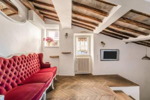 a living room with a red couch and a tv at Scala Lovely Terrace Apartment in Rome