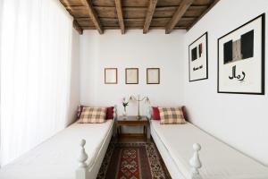 een kamer met 2 witte bedden en een tapijt bij Farnese Charming Apartment in Rome