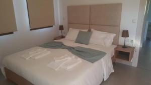 ein Schlafzimmer mit einem weißen Bett mit zwei Handtüchern darauf in der Unterkunft Palataki Margariti in Margarítion