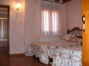 una camera da letto con due letti e una finestra di Hotel Rural El Museo a Cedillo de la Torre Altre 12 foto
