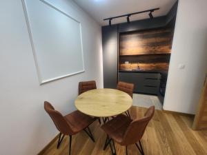 een eetkamer met een houten tafel en stoelen bij Eleven Apartment in Podgorica
