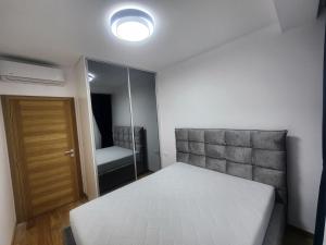 een kleine slaapkamer met een bed en een spiegel bij Eleven Apartment in Podgorica