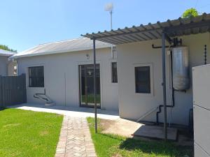 ein weißes Haus mit einem Zaun in der Unterkunft Olive Tree Studio Apartment in Harrismith