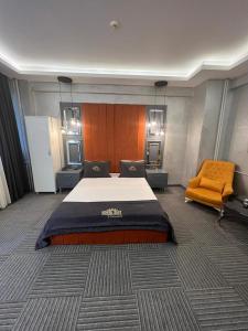 1 dormitorio con 1 cama grande y 1 silla naranja en Royal Suit Premium, en Estambul