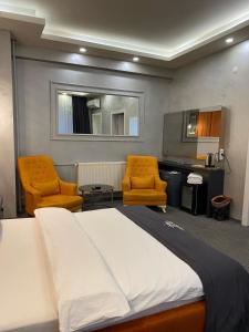 sypialnia z 2 krzesłami, łóżkiem i biurkiem w obiekcie Royal Suit Premium w Stambule