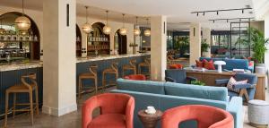 a restaurant with blue and orange chairs and a bar at The Store in Oxford