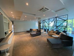 una gran sala de estar con sofás, mesas y ventanas. en SP Stays Emotion - Brooklin en São Paulo