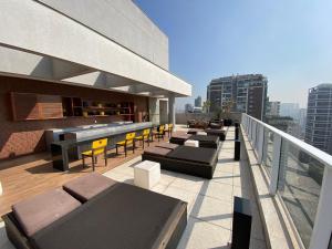 un balcón con sofás y sillas en un edificio en SP Stays Emotion - Brooklin en São Paulo
