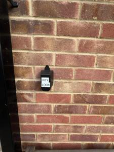 a sign on a brick wall with a new box at Private Apartment in Windsor in Windsor