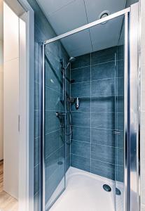 een glazen douche in een badkamer met blauwe tegels bij Rezidence Mozart in Praag