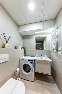 een badkamer met een wasmachine en een wastafel bij Rezidence Mozart in Praag