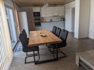 a kitchen with a wooden table and black chairs at Ferienwohnung Lang in Nittenau