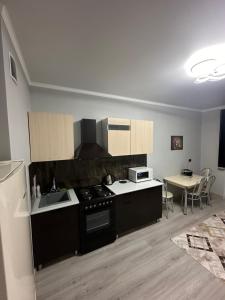 uma cozinha com um fogão, um lavatório e uma mesa em Апартаменты Один день или неделя em Kirovo