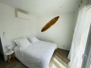 um quarto com uma cama branca e uma folha grande na parede em Casa Felicita em Bastelicaccia