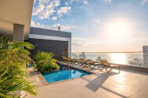 a balcony with a pool and chairs on a building at Exclusive Luxury Apartment 2 BRD In Rodadero in Gaira