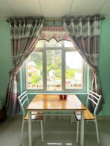 a table and two chairs in front of a window at Bee Backpackers Hostel in Quang Binh