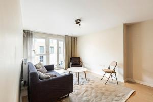 un soggiorno con divano e tavolo di Sleek Apartment in Belgravia a Londra