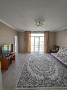 Sala de estar amplia con cama y TV en Квартира 3-х комнатная, en Madaliabad