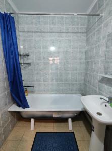 y baño con bañera blanca y lavamanos. en Квартира 3-х комнатная, en Madaliabad