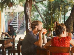 een man en vrouw aan een tafel in een restaurant bij La Posada - Hostel in Santa Teresa Beach