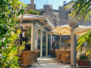 an outdoor patio with chairs and an umbrella at La Casa al Torrente in Riva del Garda