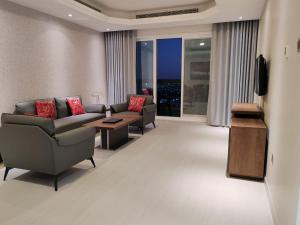 a living room with two couches and a television at Corniche Tower in Ajman 