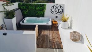 uma banheira sentada num deque com plantas em Villa piscine balnéothérapie entièrement privée em Barras
