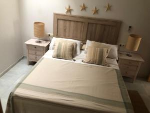 ein Schlafzimmer mit einem großen weißen Bett mit zwei Nachttischen in der Unterkunft Casa De La Luz in Tarifa