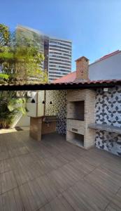 a patio with a brick fireplace next to a building at Espaço para sentir-se bem. in Fortaleza