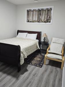 a bedroom with a bed and a chair at Feel At Home in Edmonton