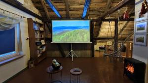 a large screen in a living room with a tv at Kaszubskie Siedlisko Szkodnikówka in Skwierawy