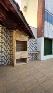 a patio in a building with a brick fireplace at Espaço para sentir-se bem. in Fortaleza