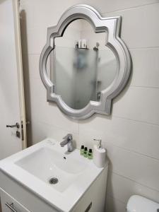baño con lavabo y espejo en la pared en Luxury Huge Suite Near the beach, en Bat Yam