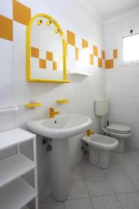 Baño blanco con lavabo y aseo en Residence La Pigna, en Rosolina Mare