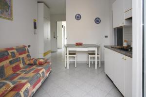 uma sala de estar com um sofá e uma cozinha com uma mesa em Residence La Pigna em Rosolina Mare