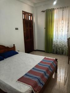 Un dormitorio con una cama con una manta de colores. en White's villa, en Matara