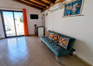 a living room with a green couch and a window at Margus in Punta Braccetto