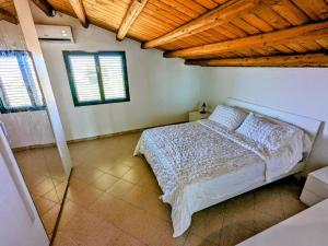 ein Schlafzimmer mit einem Bett und zwei Fenstern in der Unterkunft Margus in Punta Braccetto