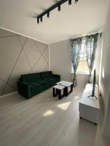 a living room with a green couch and a table at J.D Apartment in Gniezno