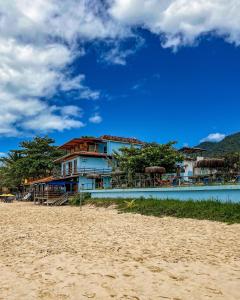 a house on the beach next to a sandy beach at Hotel Garni Cruzeiro do Sul in Trindade