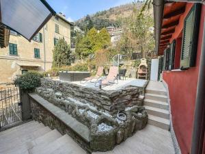 - un mur en pierre à côté d'un bâtiment avec une terrasse dans l'établissement Como - Magic Garden House - Lake View, à Côme