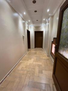 un corridoio vuoto con pavimenti in legno e una porta di فيلا دورين وملحق a Muná