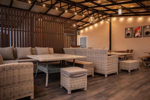 a restaurant with wicker chairs and tables and a table and chairs at Miki House in Chumphon