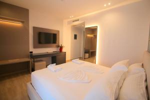 um quarto de hotel com uma cama branca e uma secretária em Onix H em Ksamil