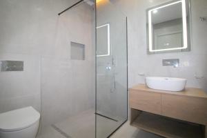 a bathroom with a shower and a toilet and a sink at Onix H in Ksamil
